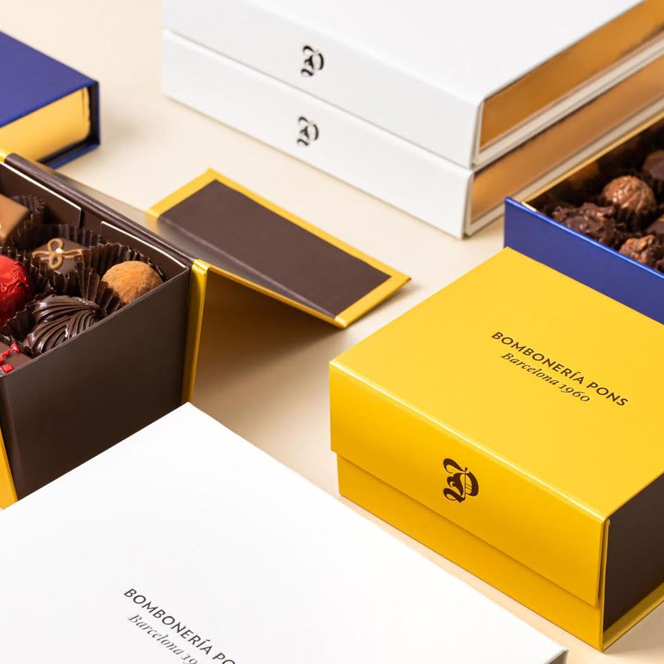 Cajas de bombones azul, amarilla y blanca de Bombonería Pons