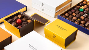 Cajas de bombones azul, amarilla y blanca de Bombonería Pons