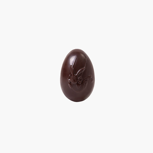 Huevo de chocolate negro para pascua con un conejo 